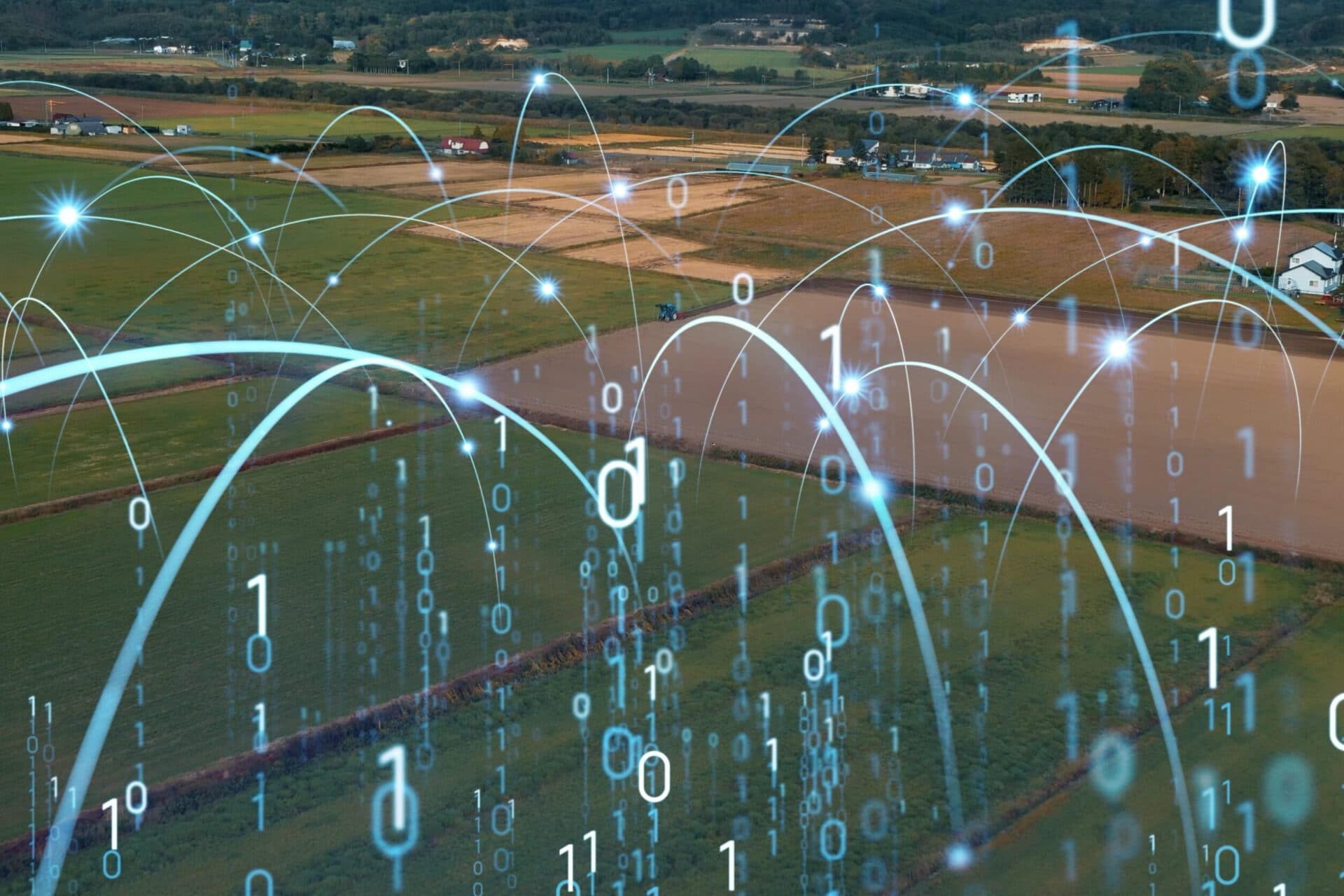 Glowing blue network lines and binary code overlaying an aerial view of rural farmland.